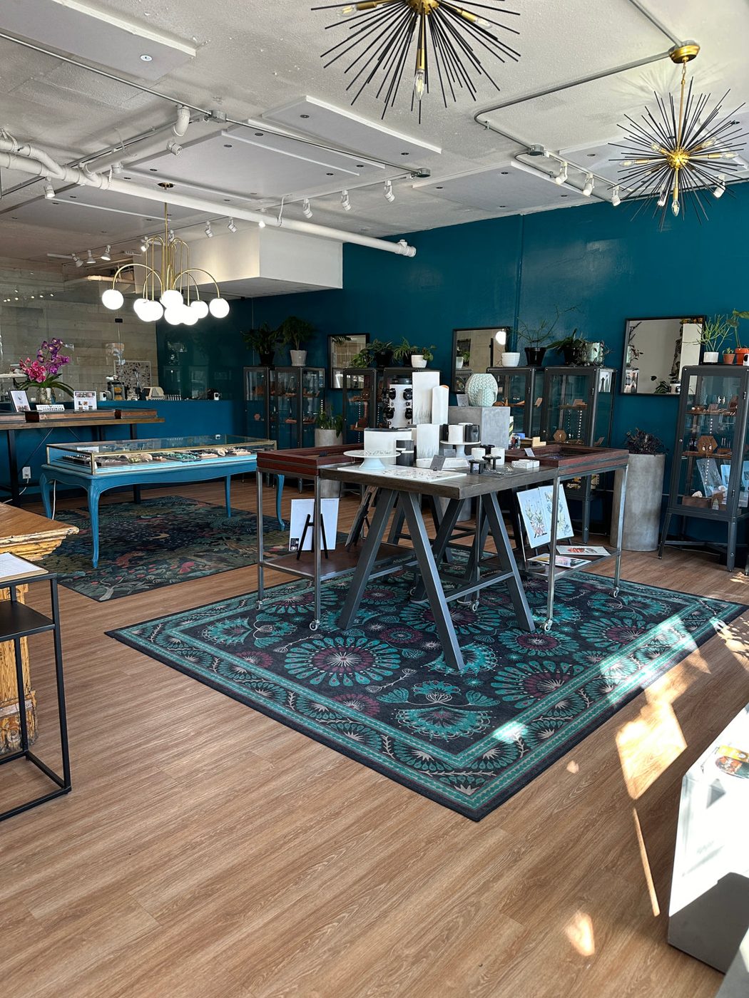 Inside the Balefire gallery, with teal walls, display cases and a patterned rug